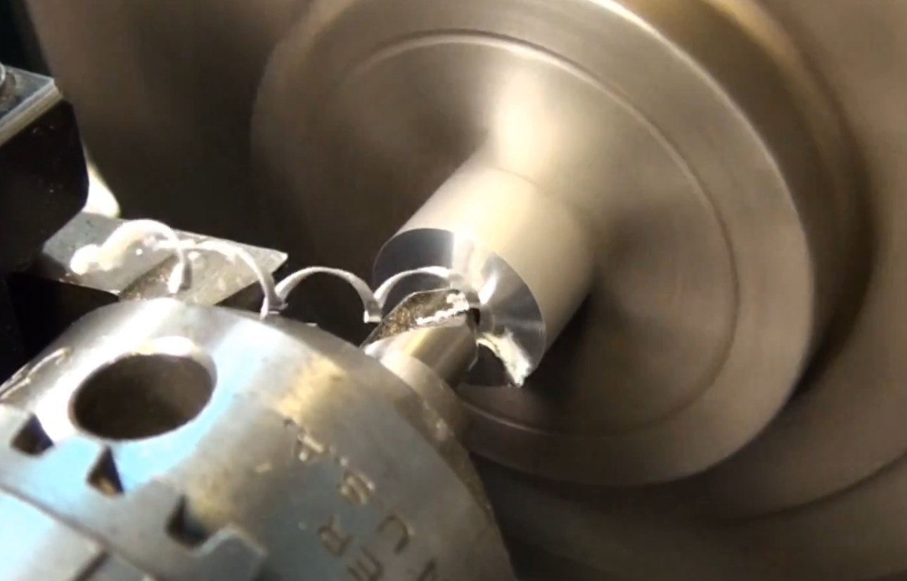 Center drill machining the end of a cylindrical workpiece on a lathe